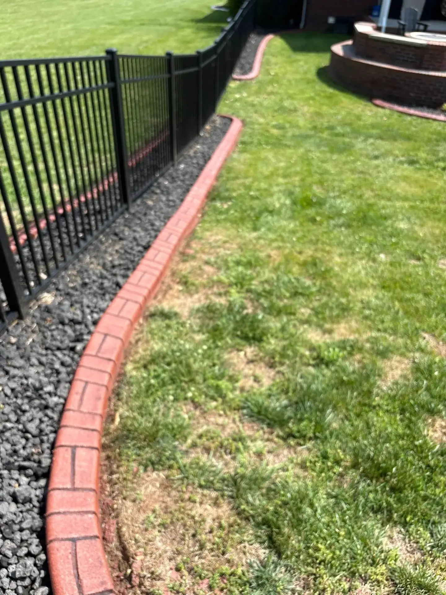 Finished stamped concrete curbing wrapping a residential planting bed