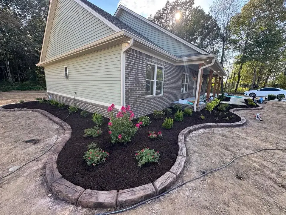 A finished landscape bed with a defined concrete edge.