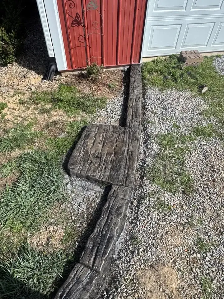 Stamped curbing detail along a narrow side-yard bed.