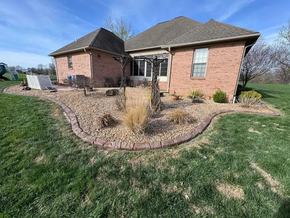 Curved concrete edging completing a residential landscape bed.