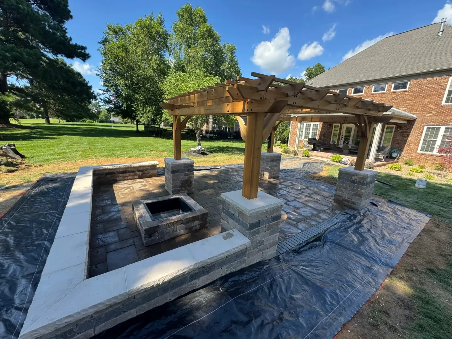 Completed paver patio, fire pit, and timber pergola outdoor living area